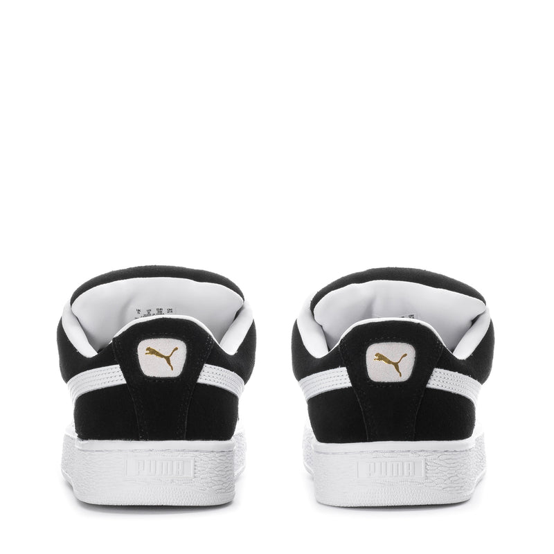 Black suede youth sneakers with white heel trim and rear logo patch
