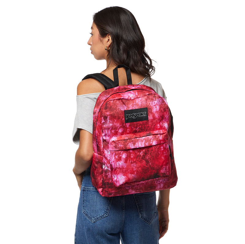 Jansport Superbreak Plus backpack, red floral print worn by person with front logo patch