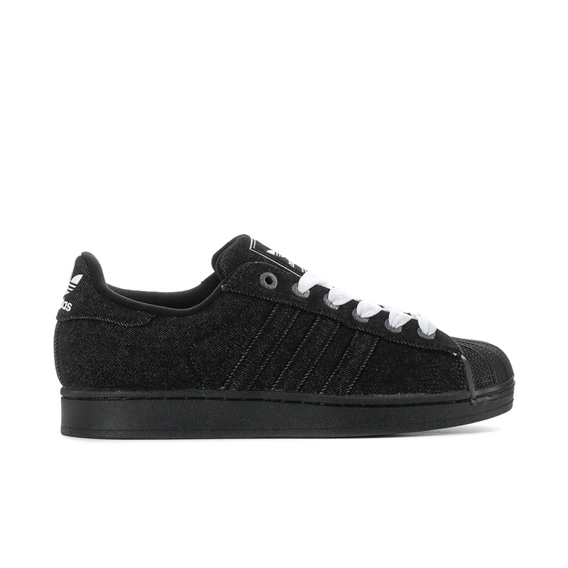 Black low-top canvas sneakers with white laces and side stripes, rubber sole