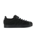 Black low-top canvas sneakers with white laces and side stripes, rubber sole