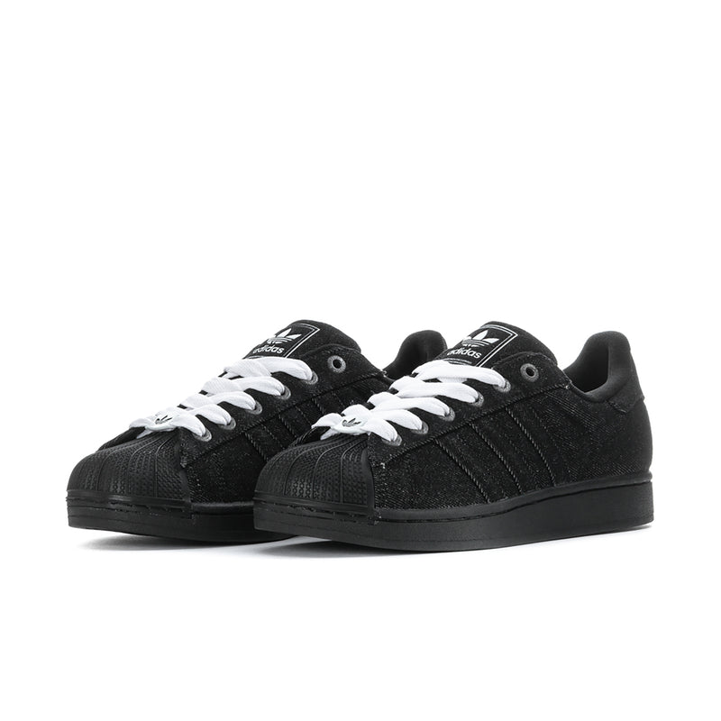 Pair of black low-top sneakers with white lace-up details and black rubber sole