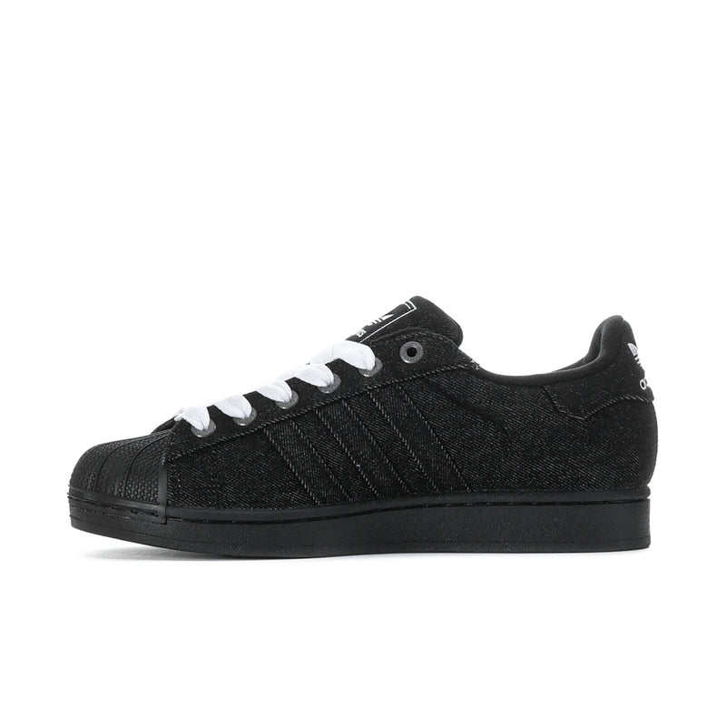 Black low-top adidas sneakers with white laces, side stripes, and black outsole