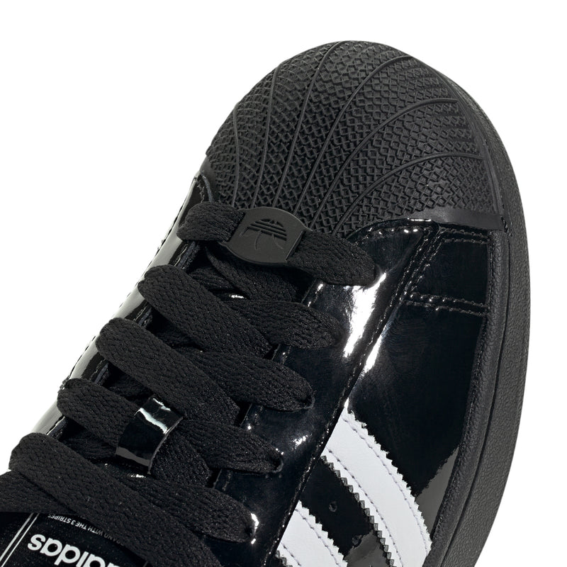 Men's adidas Superstar II sneakers close-up, black glossy upper with white side stripes.