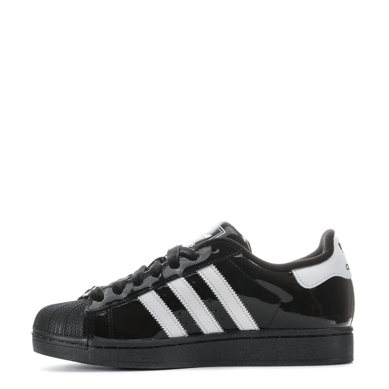 Youth low-top sneakers with white side stripes, black glossy upper, and lace-up