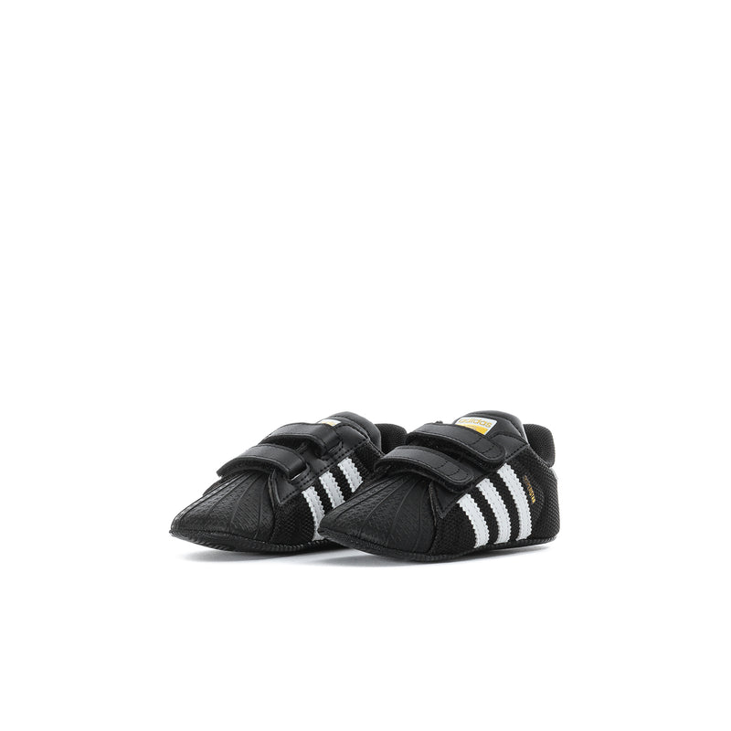 Infant black adidas Superstar sneakers shown from side with double Velcro straps