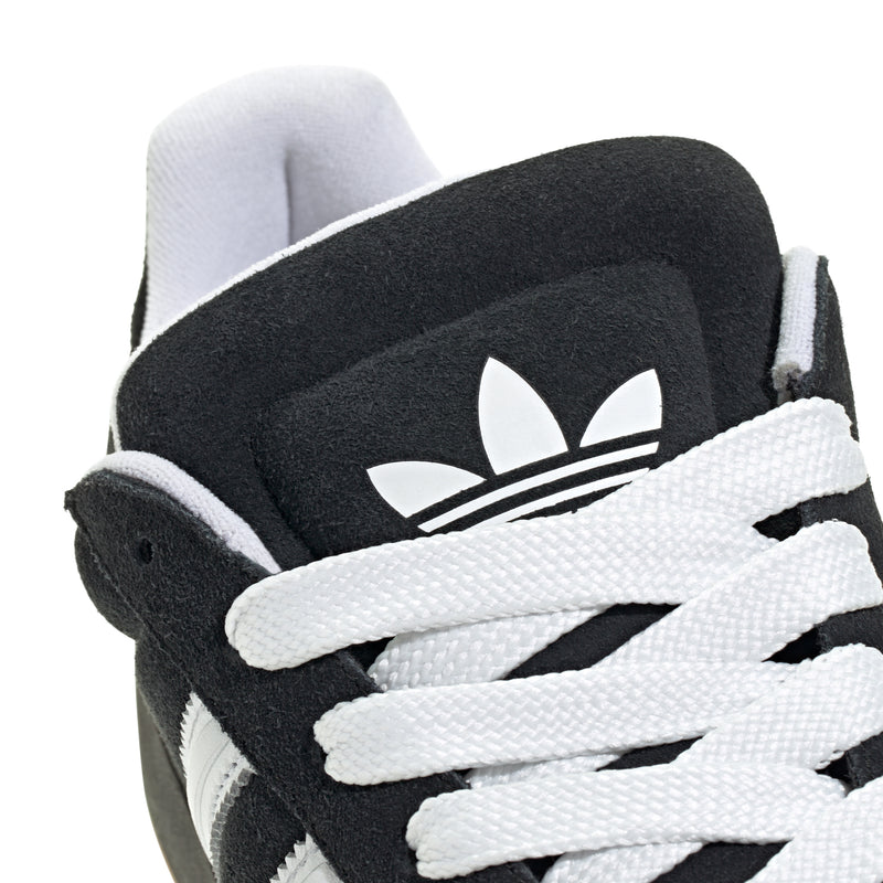 Close-up of black and white adidas-style sneakers with large logo patch and strap.
