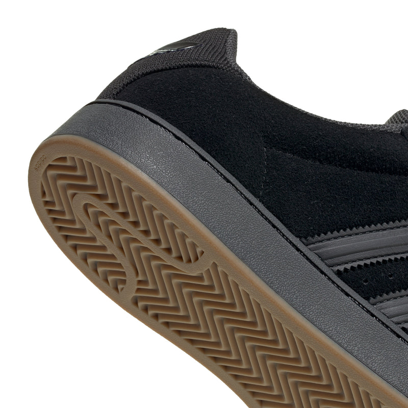 Superstar ST men's sneakers close-up, gum outsole with textured tread and black upper