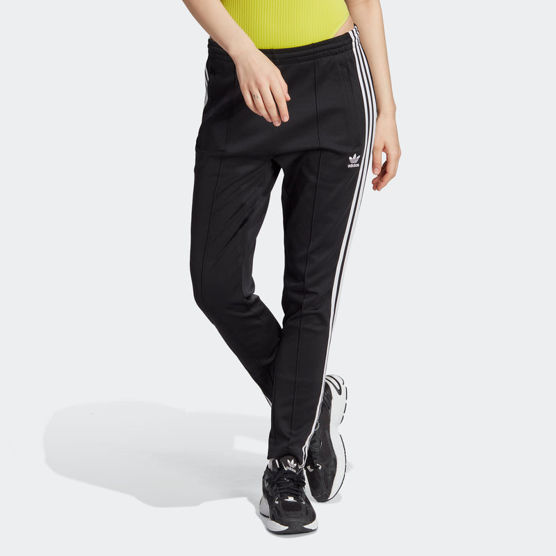 Women's black track pants with three white stripes, ankle-length tapered leg