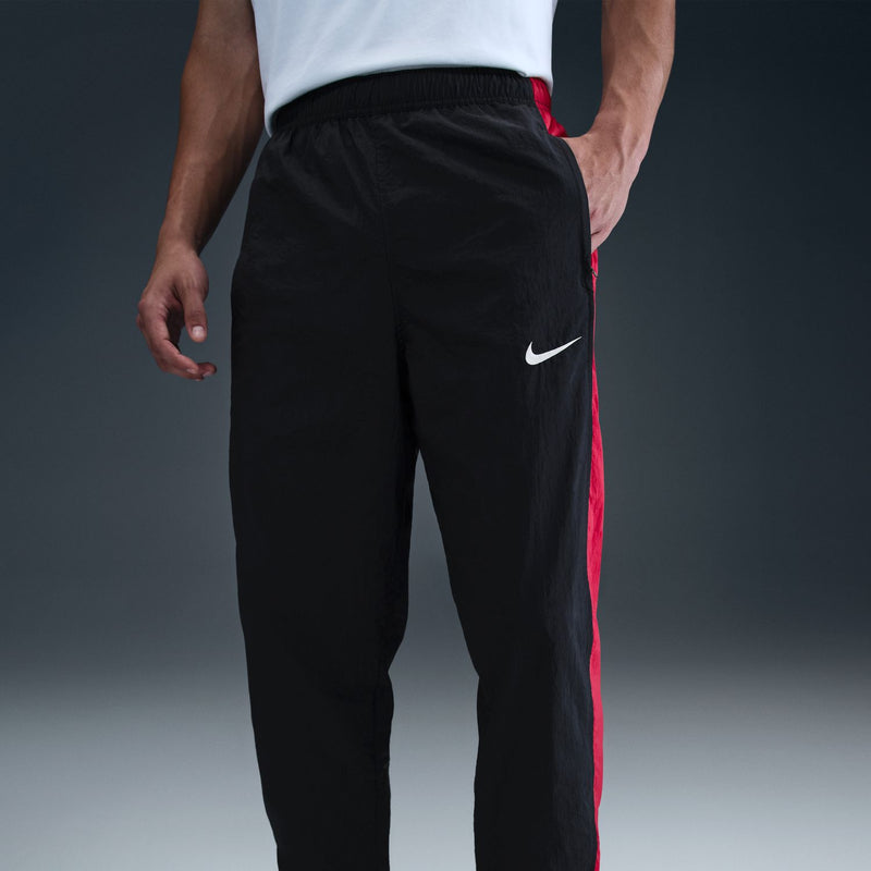Men's black track pants, red side stripe, Nike swoosh on thigh