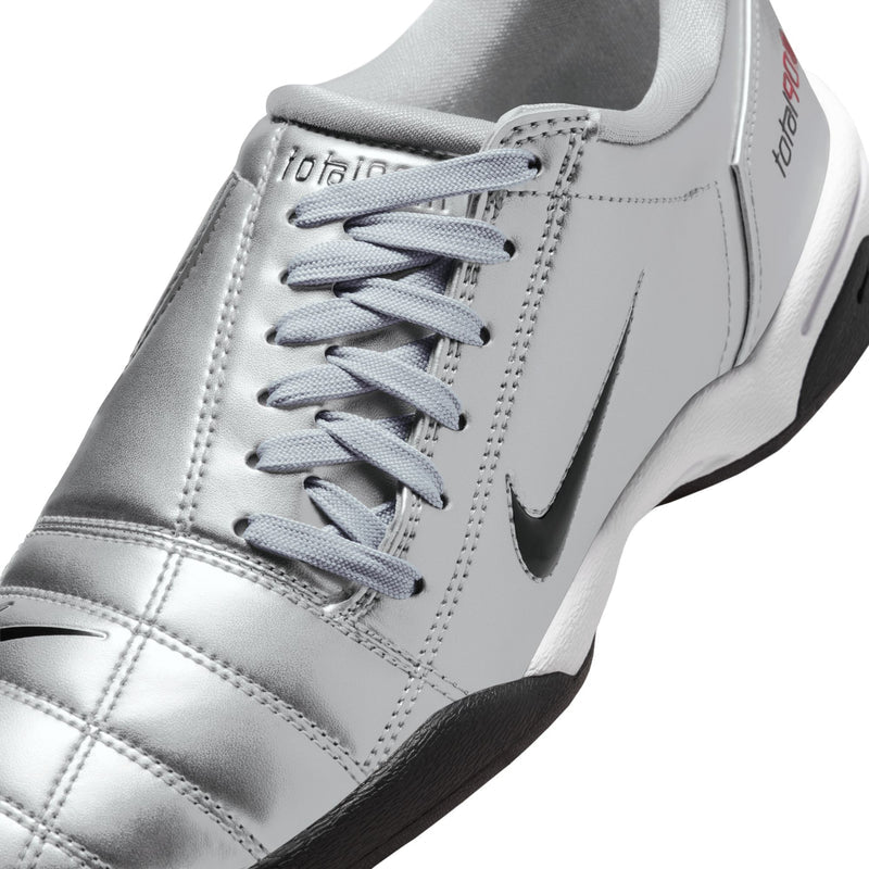 Metallic silver women’s sneaker upper close-up with gray laces and side swoosh