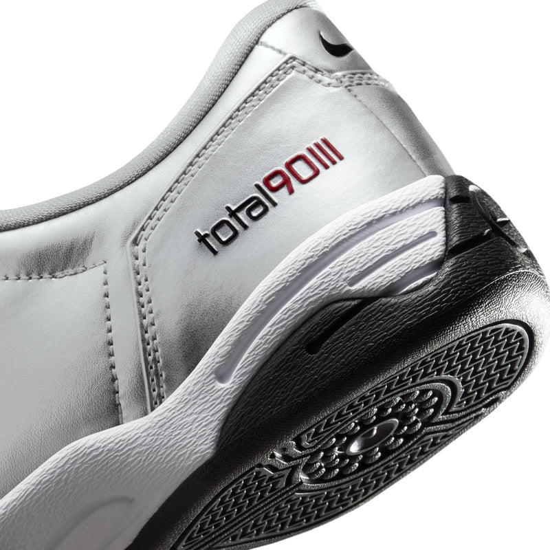 Metallic silver women’s sneaker side detail with red triple-III logo and black rubber sole