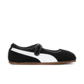 Women's black suede slip-on flats with white stripe, buckle strap, and gum sole.