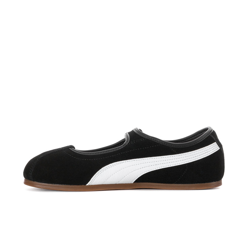Women's black suede flat shoes with a white diagonal stripe and gum outsole.