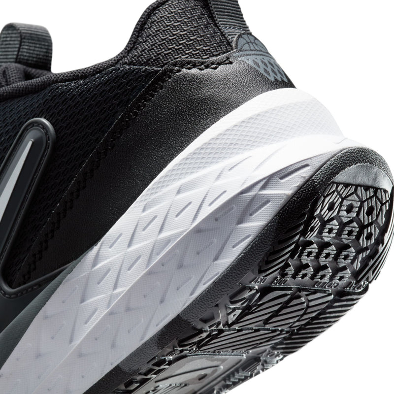 Youth Nike sneaker outsole close-up with tread pattern and black upper edge