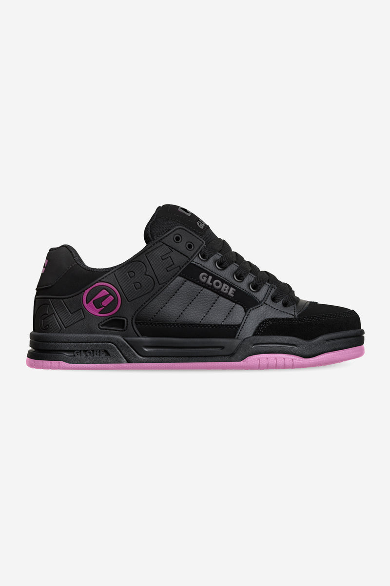 Side view of Tilt skate shoe in black with gray panels and pink outsole accents.
