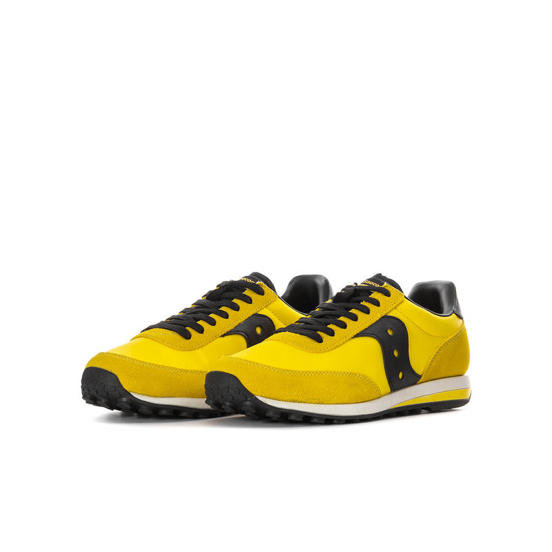 Pair of youth lace-up running shoes in bright yellow with black panels and chunky sole