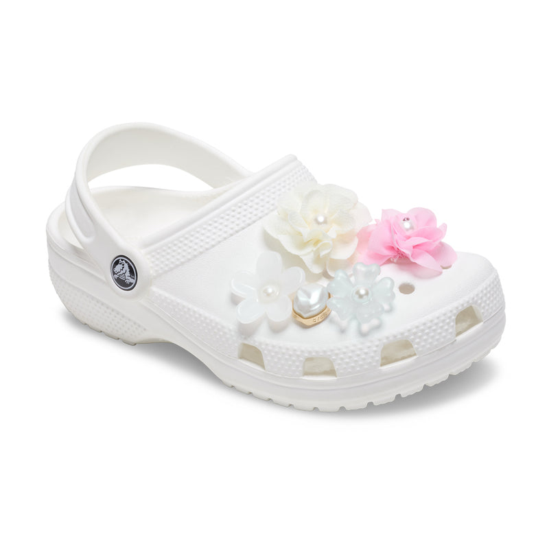 Flower Jibbitz charms on white clog strap: white, pink, and pearl accents