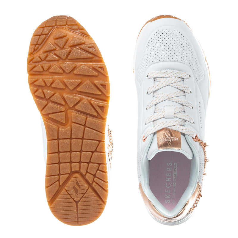 Youth white sneaker sole view with brown tread and rose-gold chain detail