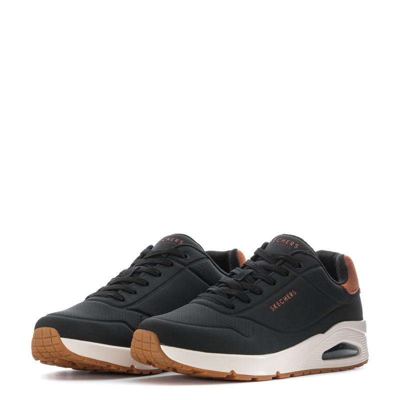 Pair of men's black low-top sneakers with tan accents and white soles