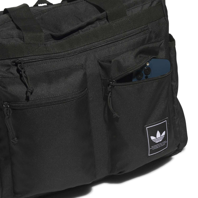 Black tote with front zip pocket detail and logo patch on the side panel.