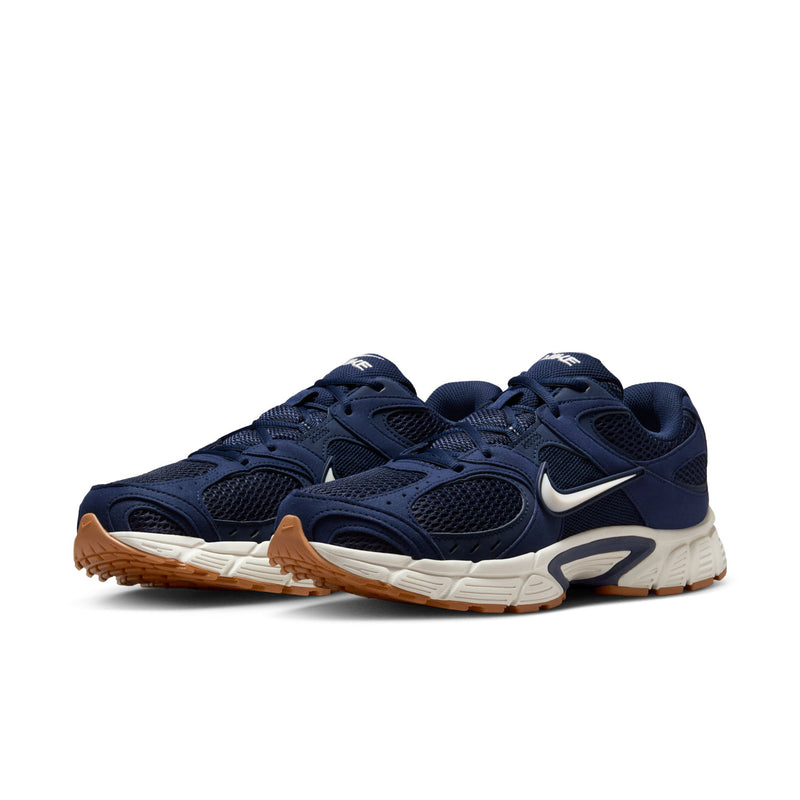 Pair of men's navy lace-up sneakers with white midsole and tan outsole