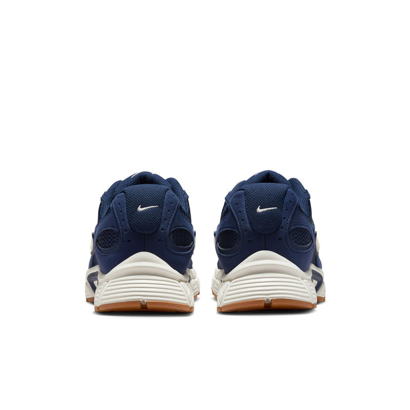 Men's navy sneakers from the back with white heel accents and tan outsole