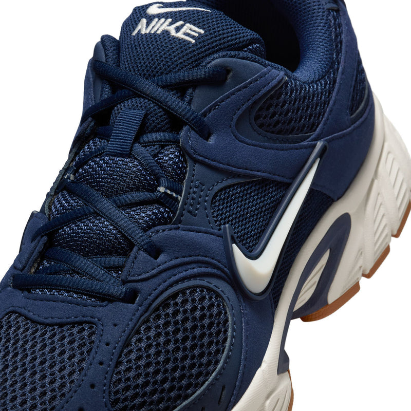 Close-up of men's navy sneaker upper with Nike swoosh and textured mesh