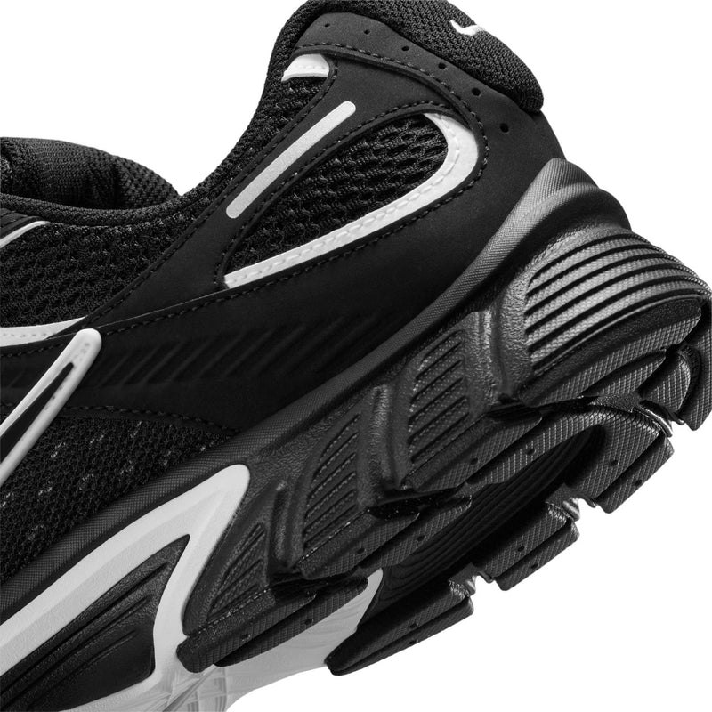 Men's black Nike running shoe close-up of side panel and ribbed midsole