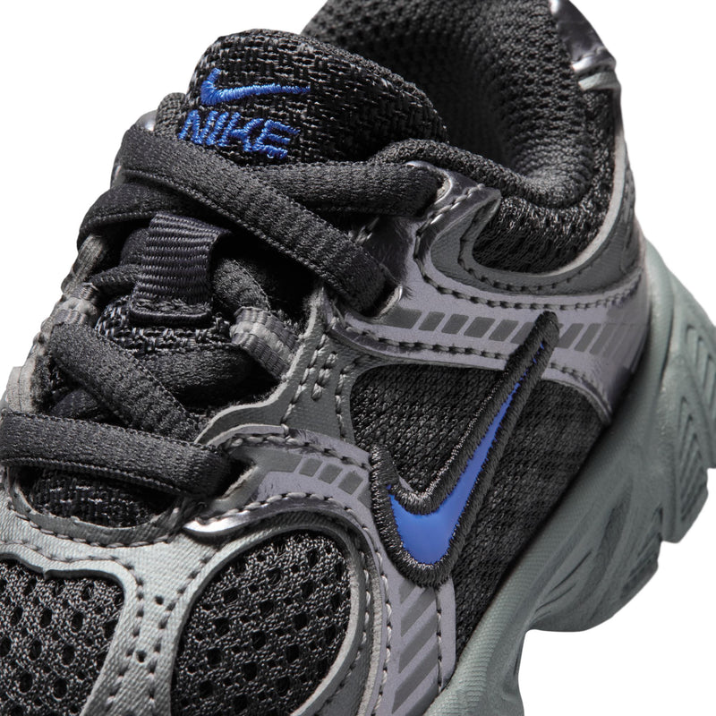 Toddler athletic sneakers close-up: black laces, blue swoosh, textured dark gray upper