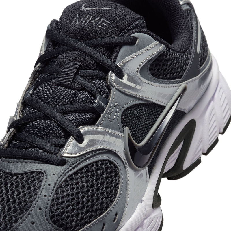 Close-up of men's black and silver running shoe upper with lace loops and Nike logo.