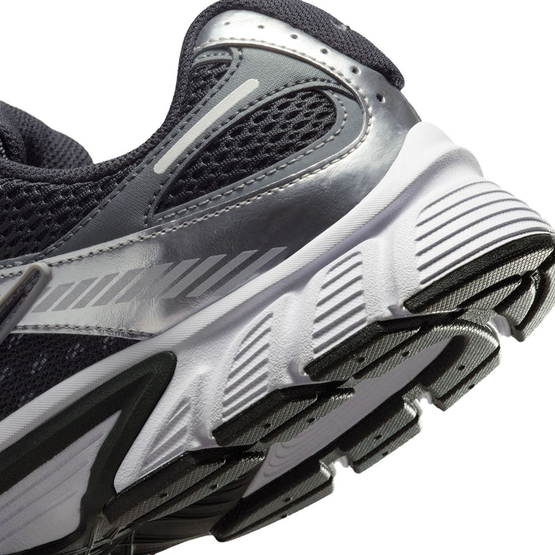 Close-up of men's shoe side outsole with black traction pods and white textured grooves.