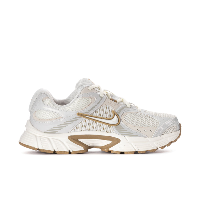 Women’s athletic sneaker in white with tan/gold accents and chunky sole