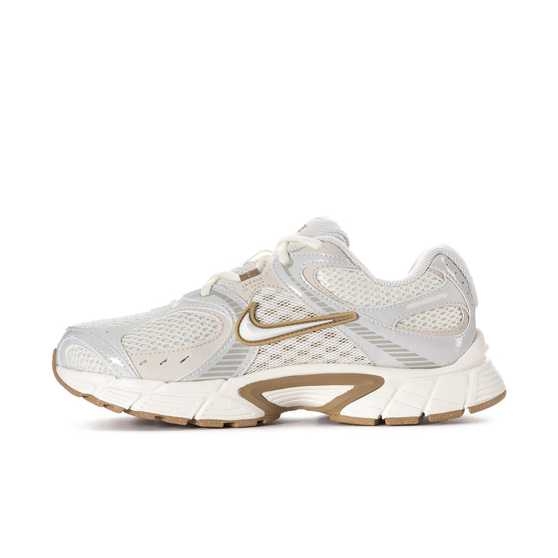 Women’s athletic sneaker angled front view, white upper with tan/gold trim