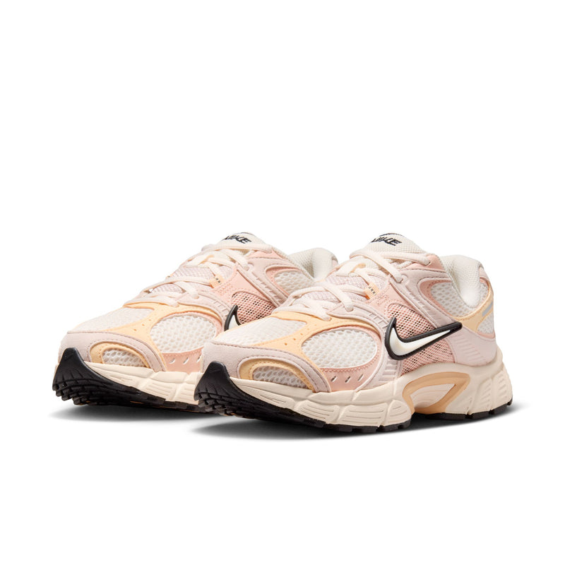 Women's running shoes in pale pink with black Nike Swoosh and orange-tan panels