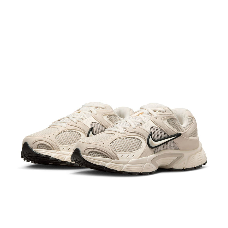 Womens cream lace-up running sneaker side view with Nike Swoosh and black details