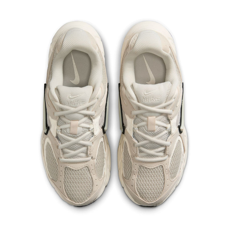 Womens cream lace-up running sneaker with light sole and Nike logo on tongue