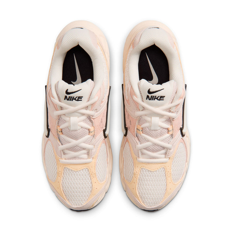 Pair of pale pink lace-up sneakers with black Nike Swoosh and white midsoles