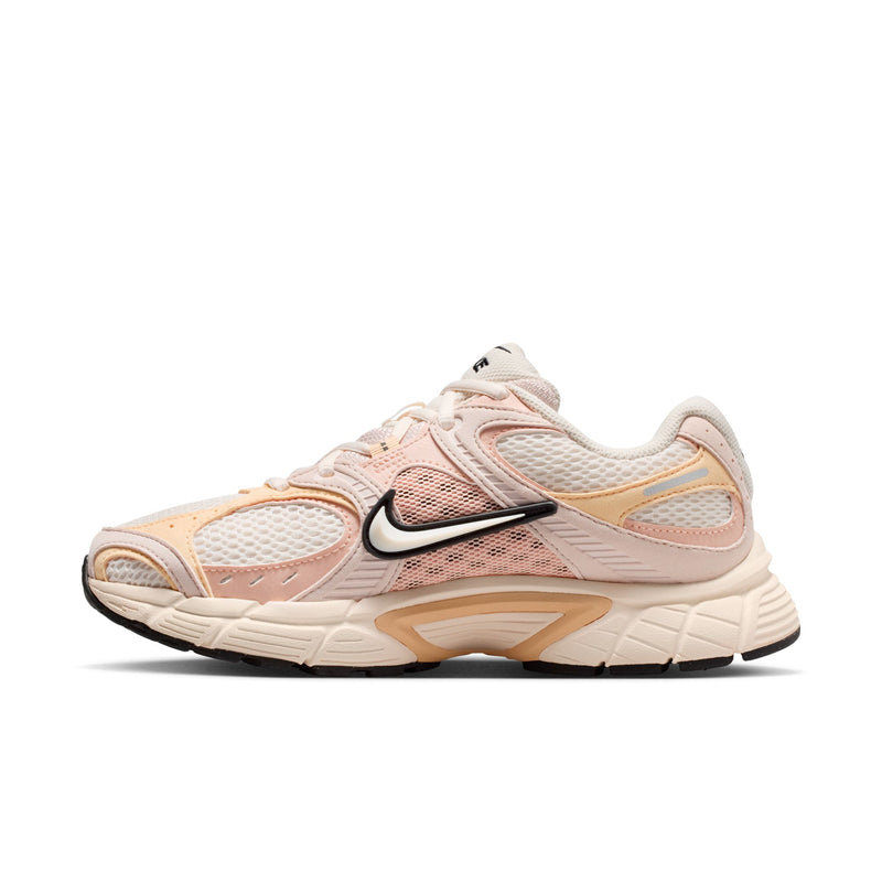Side view of pale pink running shoes with black Nike Swoosh and tan outer panels