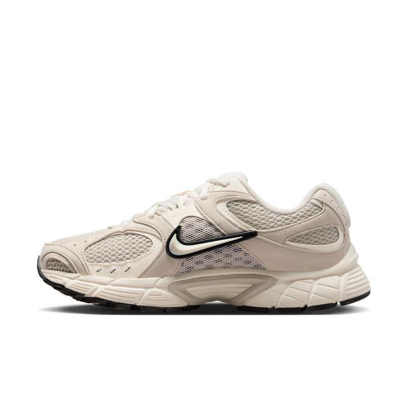 Womens cream lace-up running sneaker angled front with Nike Swoosh and black trim