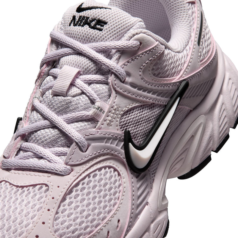 Lilac Nike sneaker close-up: lace-up mesh upper and black Swoosh