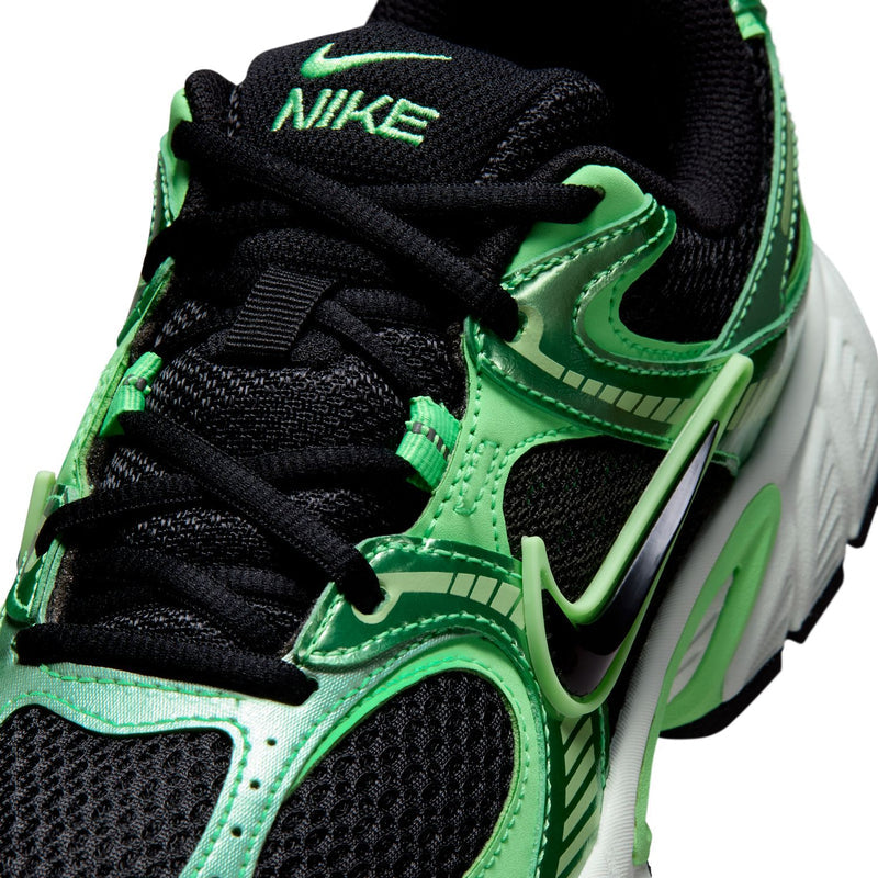 Women's green and black sneaker close-up with laces, Nike swoosh, and textured panels