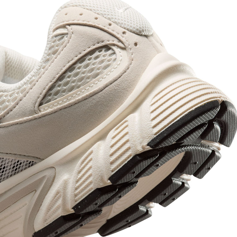 Womens cream running sneaker close-up of side panels and black traction outsole