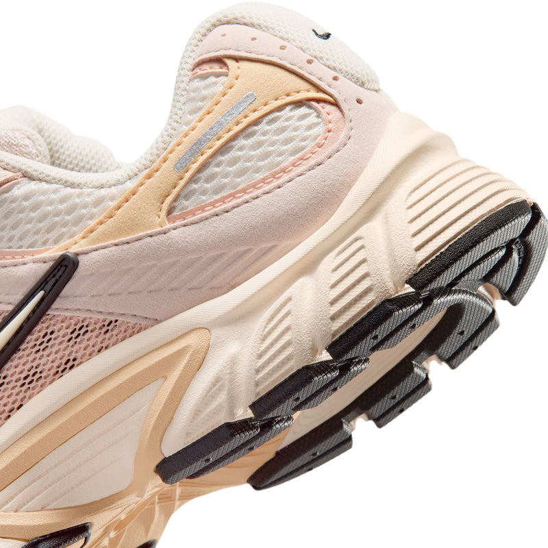 Close-up of pale pink sole with black traction strips and tan side accents