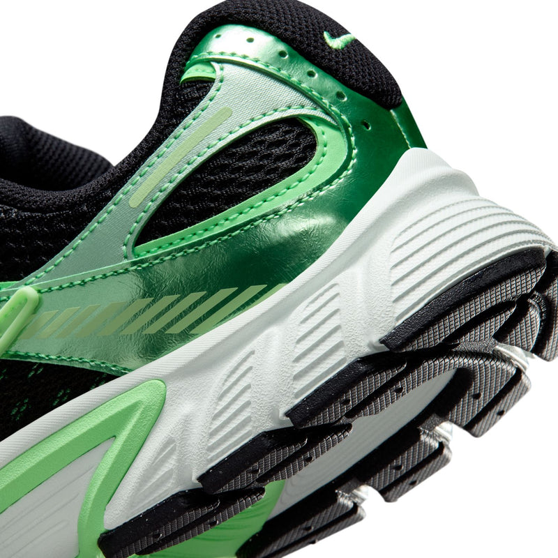 Women's green and black sneaker close-up showing white outsole and green side panel