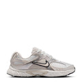 Youth white running sneaker with black swoosh, mesh upper and chunky midsole