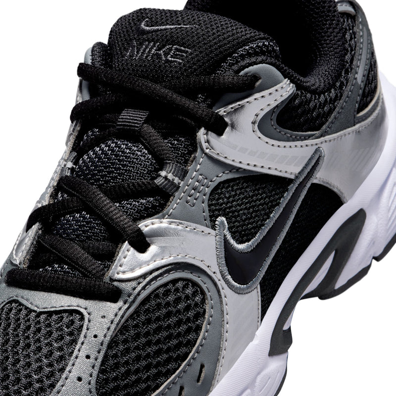 Close-up of black and silver youth running shoe with Nike swoosh and lace strap