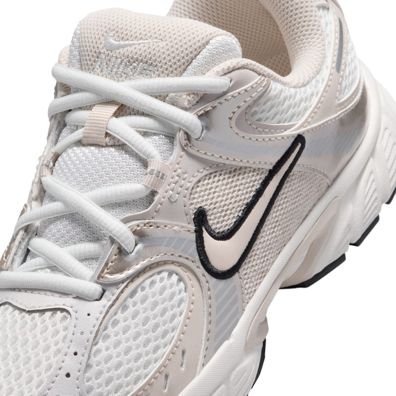 Youth white sneaker close-up, lace-up mesh upper with black swoosh logo