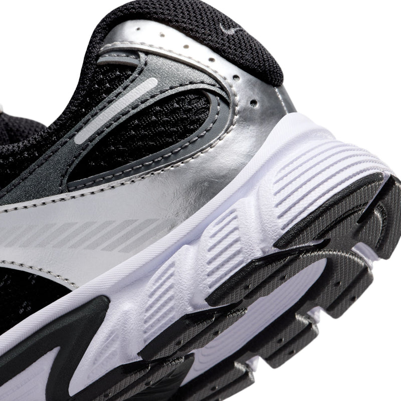 Youth running shoe side close-up with Nike logo and textured tread outsole