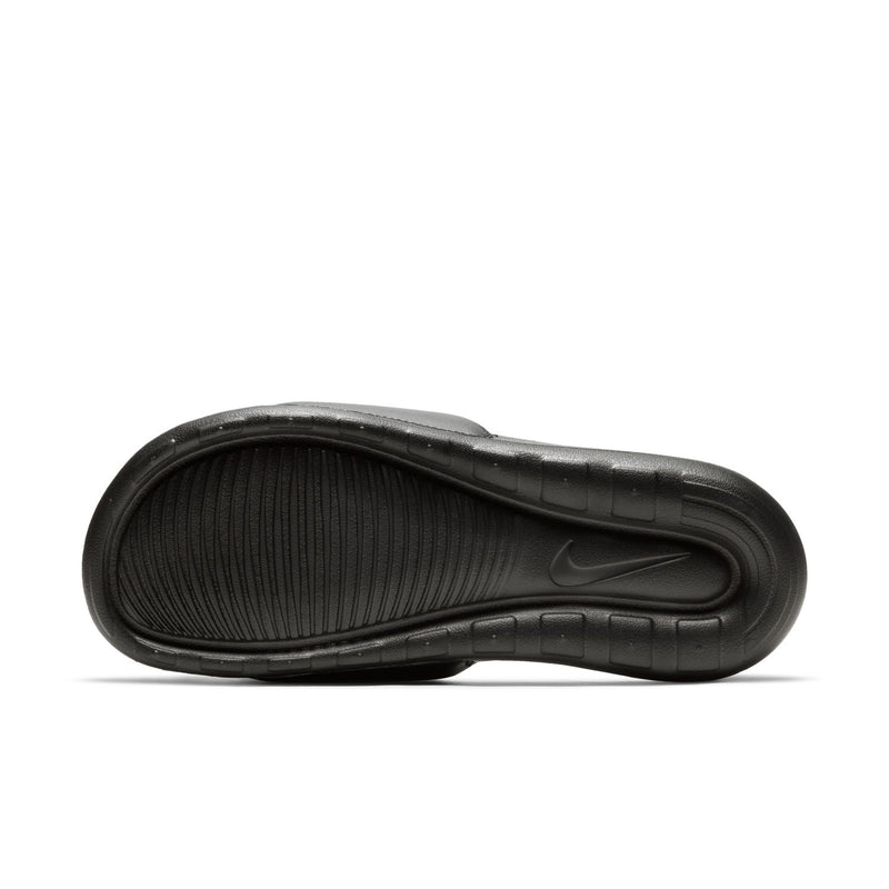 Women's black Nike slide sandals, side view of the textured footbed and outsole