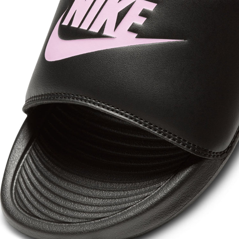 Close-up of women's black Nike slide strap with light pink logo and stitched edges